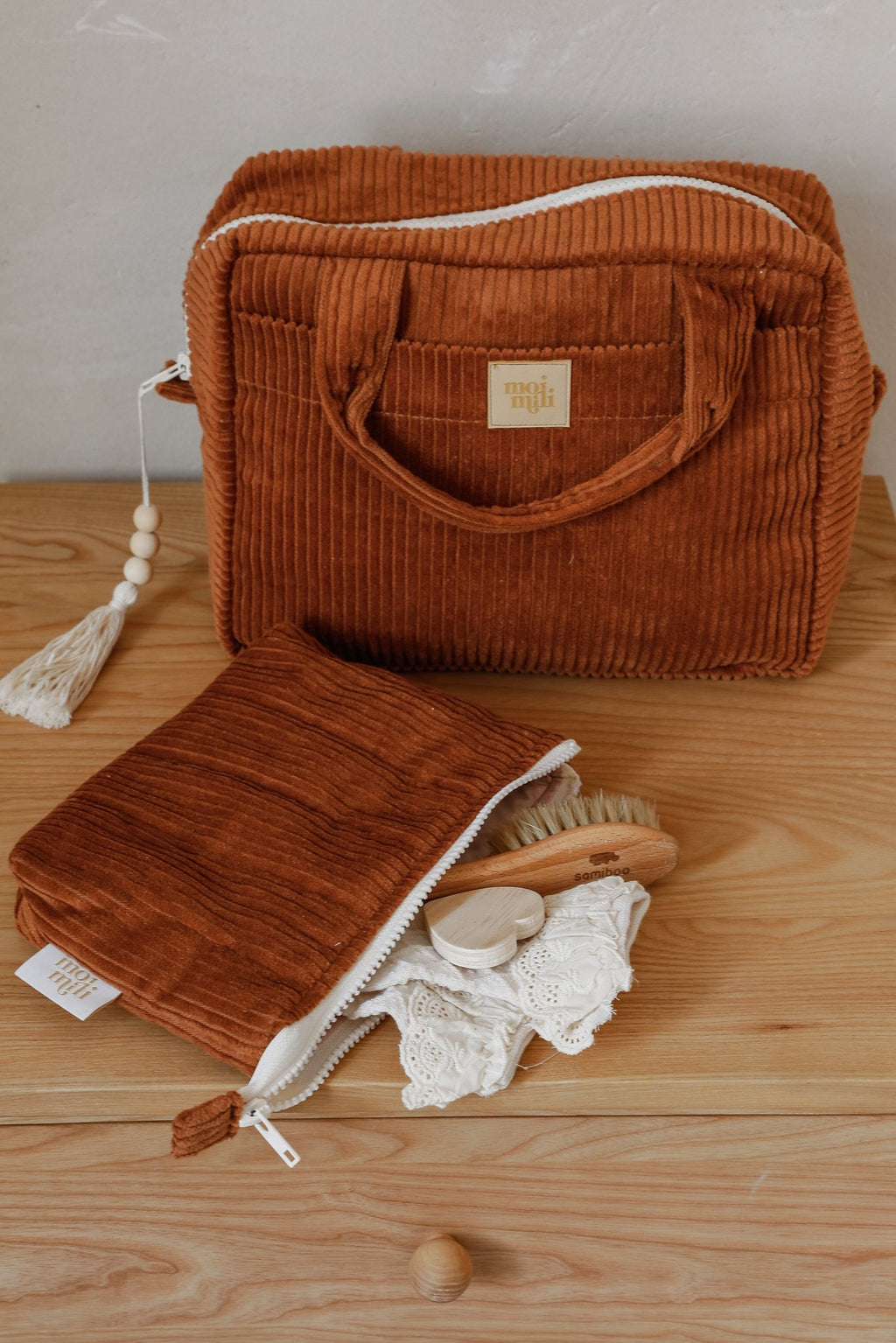 4. Caramel makeup bag set on wooden surface, large bag with handles and small bag with zipper, containing toiletries