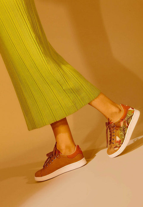 3. Women's Mangará embroidery suede sneakers in brown, styled with a green skirt, shown in a lifestyle setting