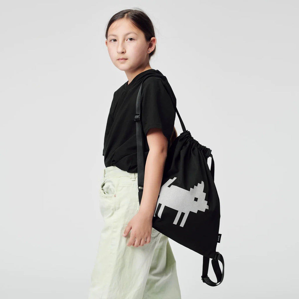 1. Young female model wearing March Design Studio's Water Resistant Reflective Backpack DOG, showcasing reflective print in studio setting