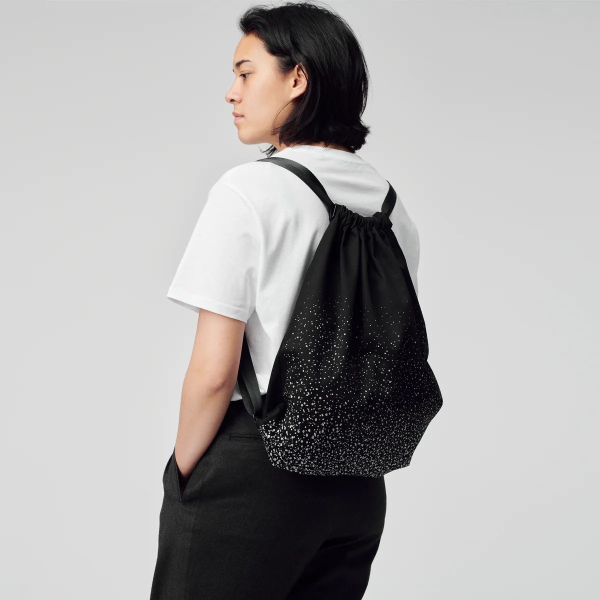 1. Woman wearing March Design Studio's Water Resistant Reflective Backpack SPLASH, showcasing reflective print and stylish design