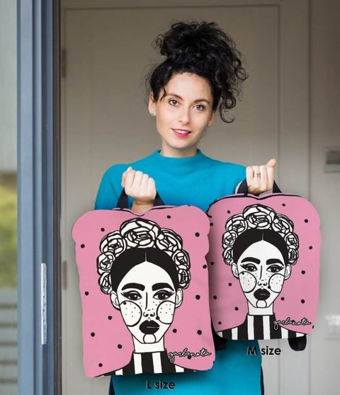 4. Studio shot of woman holding two sizes of pink MARGO backpacks by Garbanota, showing L and M sizes