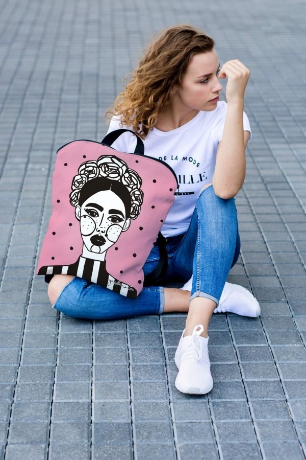 6. Woman sitting on pavement with pink MARGO backpack by Garbanota, showcasing artistic design