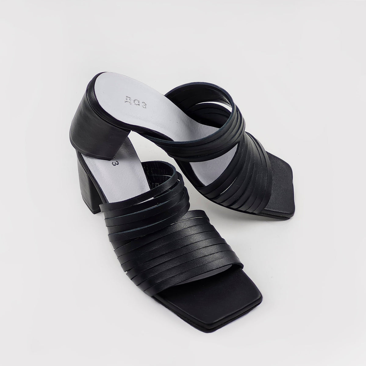 5. Angled view of women's black leather sandals with strappy design and squared toe