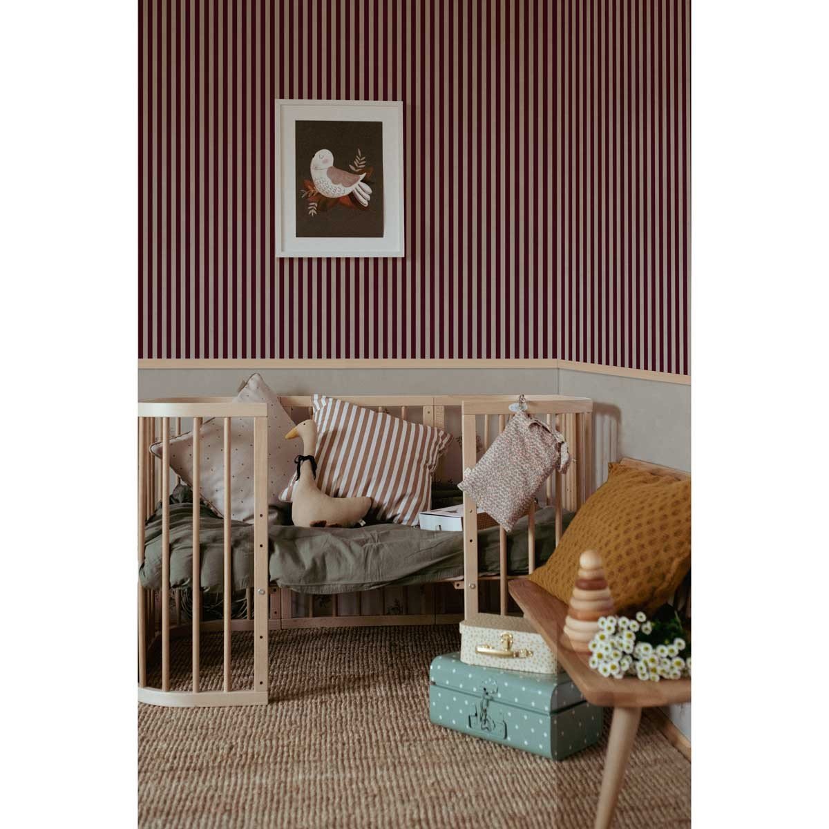 1. Children's room with cherry brown and beige striped wallpaper, wooden crib, and decorative pillows, creating a cozy and stylish atmosphere