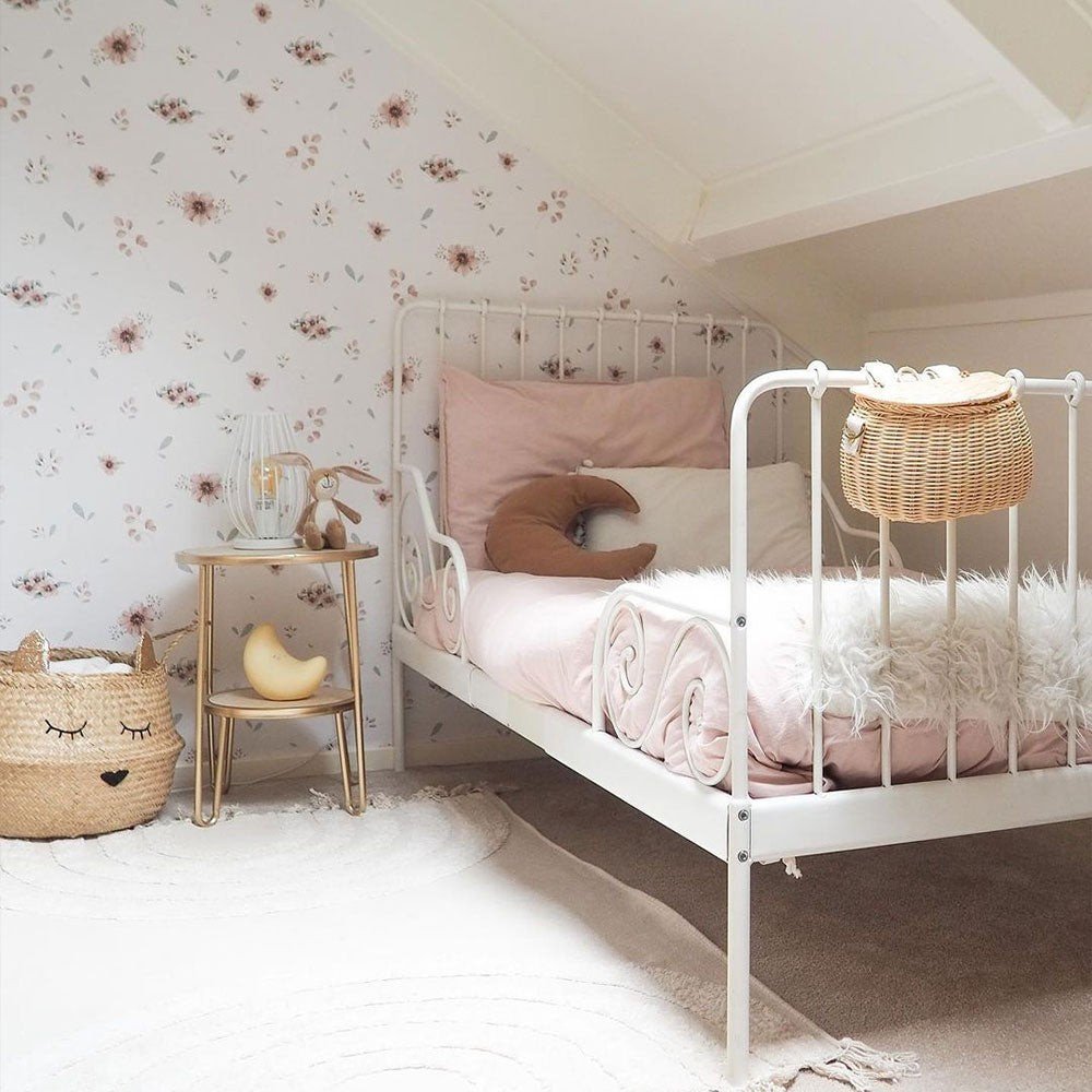 3. Children's bedroom with a white metal bed and Dekornik's Flowers Minimini Wallpaper featuring soft floral patterns on the walls
