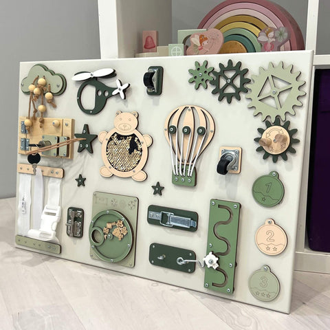 2. Close-up of Montessori busy board showing various interactive elements including a bear, hot air balloon, and gears, in green and beige, by BusyBunnyToys.