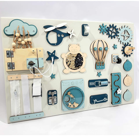 5. Montessori busy board with blue and beige interactive elements like a bear, gears, and locks, designed for sensory play, by BusyBunnyToys.