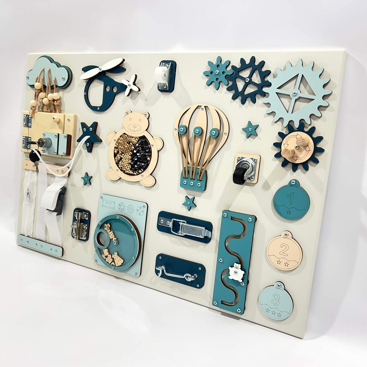 3. Studio shot of Montessori busy board with blue and beige interactive elements like a bear, gears, and locks, designed for sensory play, by BusyBunnyToys.