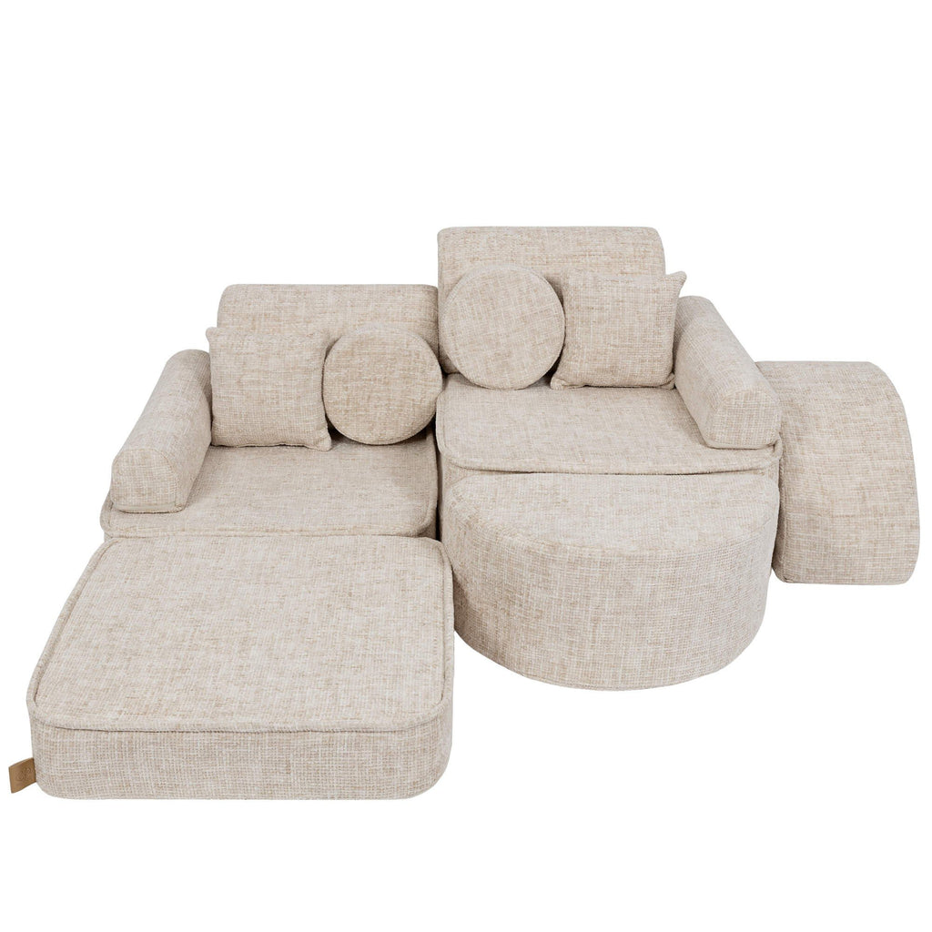 3. Beige modular children's sofa with cushions, arranged with one section extended, on a white background