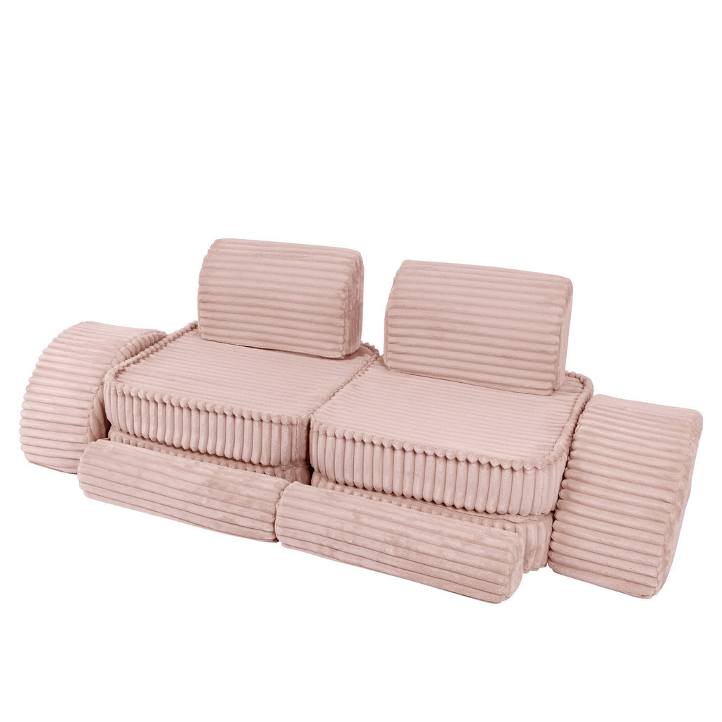 8. Medium modular kids sofa in churros pink with ribbed corduroy fabric, arranged in a low, extended layout with cushions.