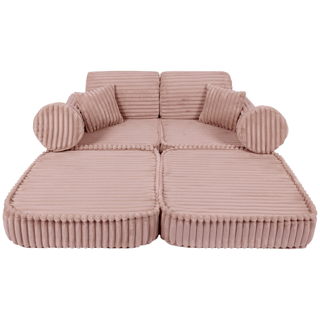 2. Medium modular kids sofa in churros pink with ribbed corduroy texture, laid flat with round and square cushions for lounging