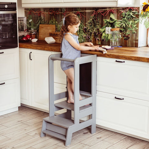 1. Child standing on dark grey MeowBaby kitchen helper preparing food on counter