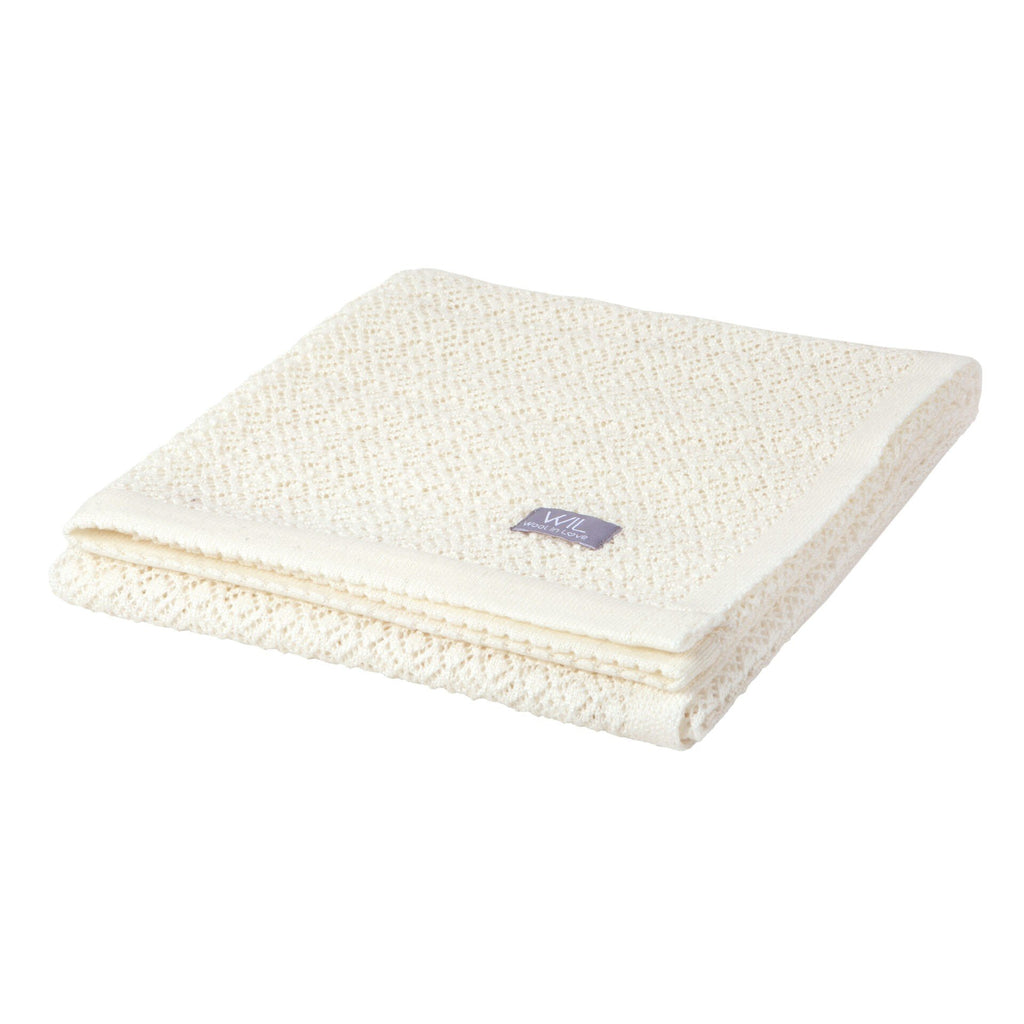2. Folded white merino wool baby blanket with Wool In Love label on clean white background