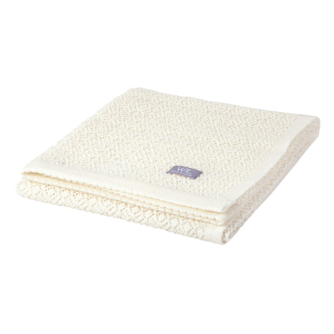 2. Folded white merino wool baby blanket with Wool In Love label on clean white background