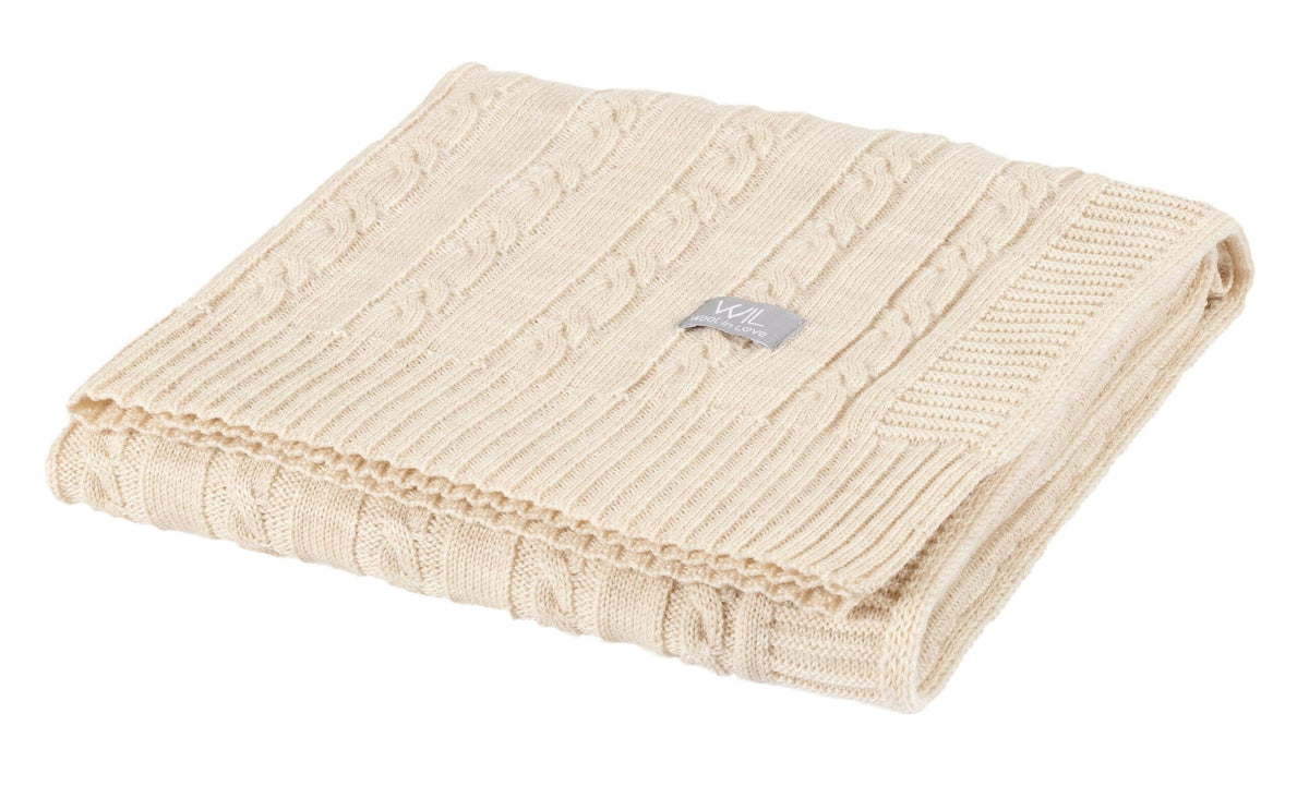 2. Folded cream merino wool baby blanket with cable knit design and Wool In Love logo on white background