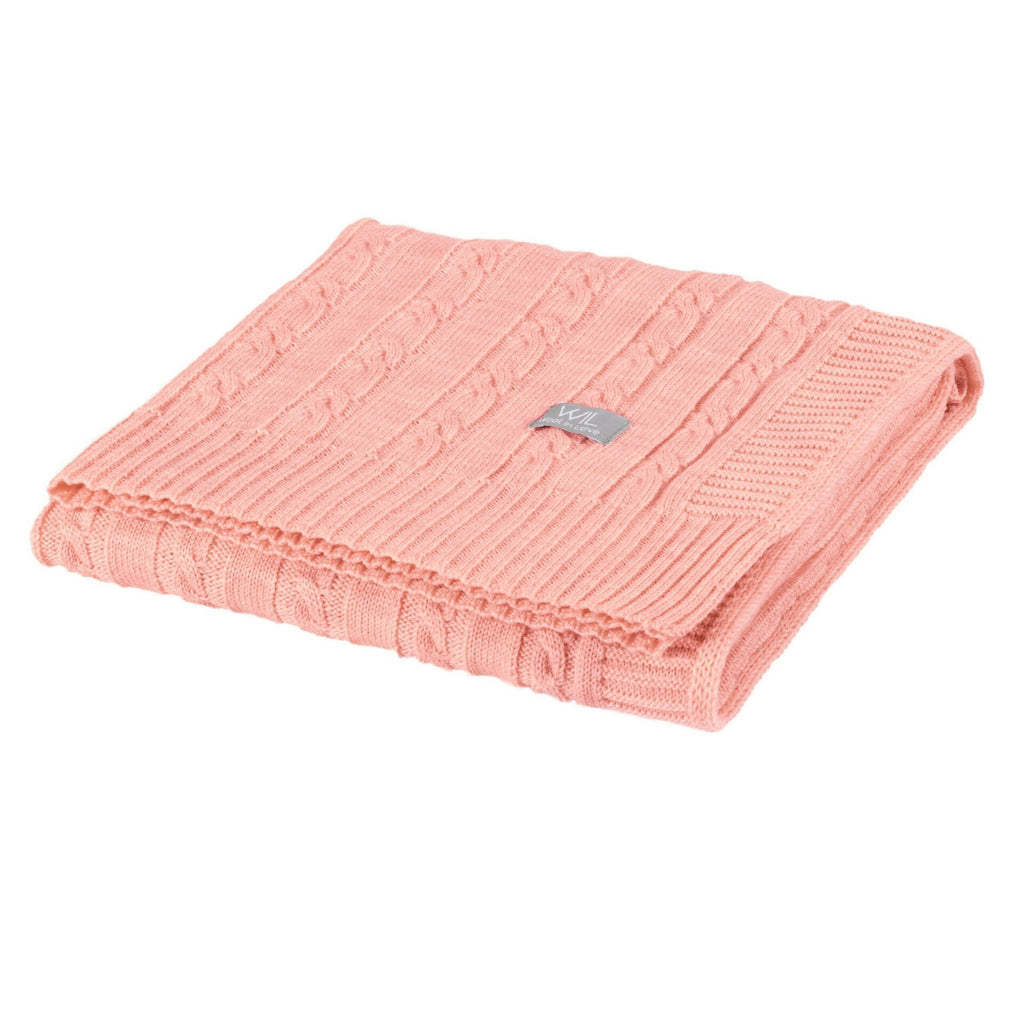 1. Folded pink merino wool baby blanket with cable knit pattern and Wool In Love logo on white background