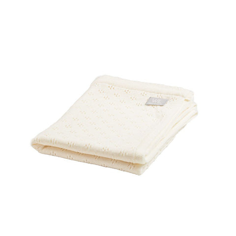 3. Folded cream merino wool baby blanket with floral pattern on white background