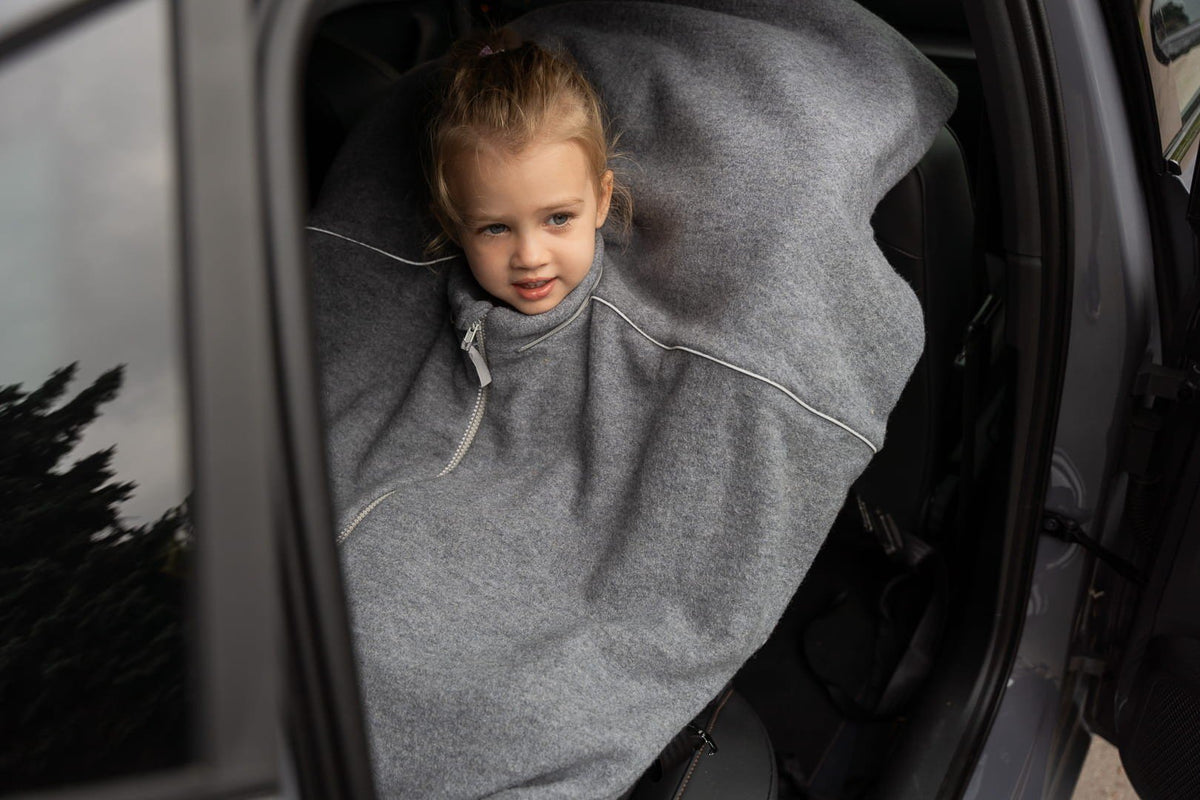 3. Child in grey merino wool poncho sitting in a car seat