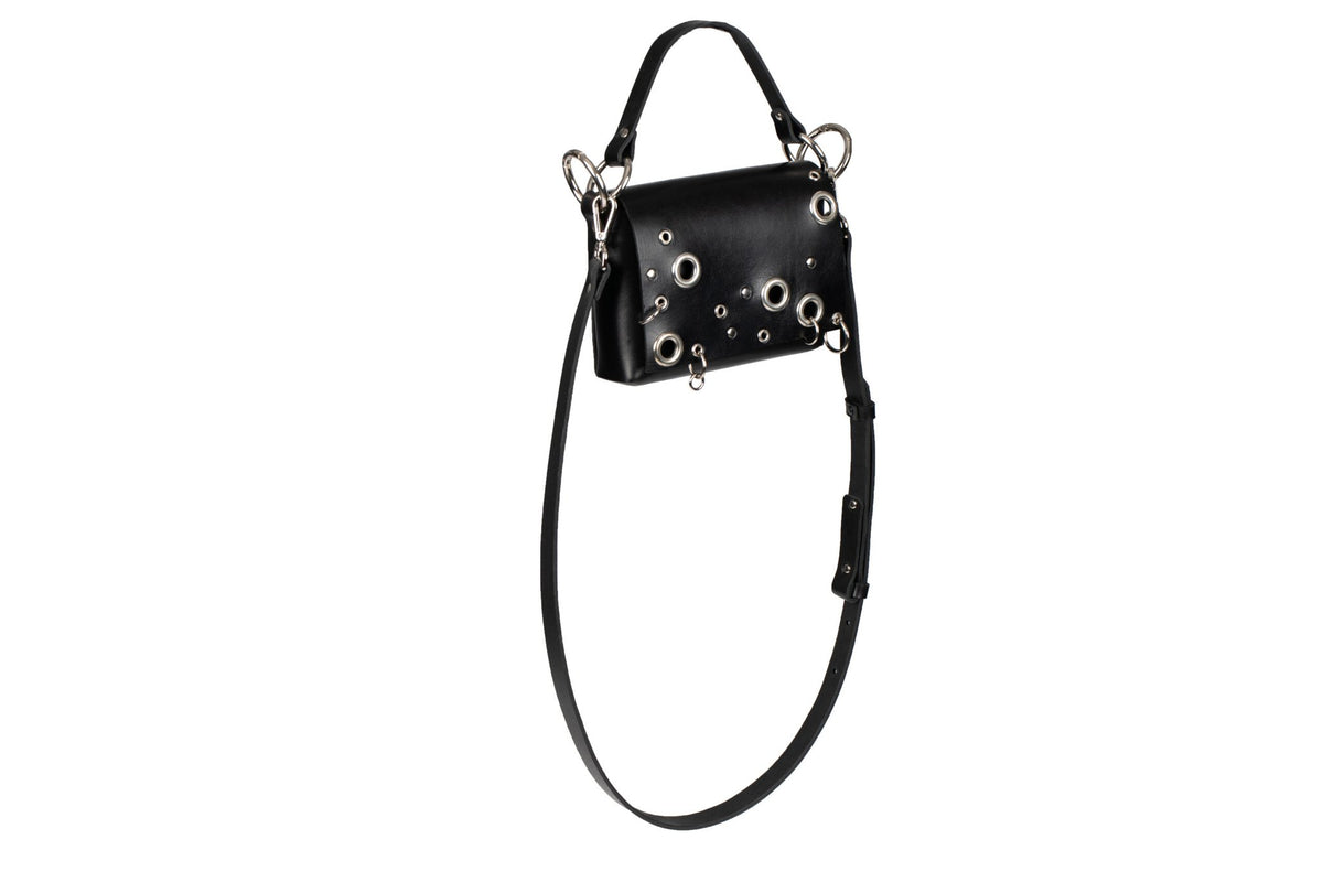 6. Side view of PYKOK Handbag Mia in black leather, showing studded design and strap