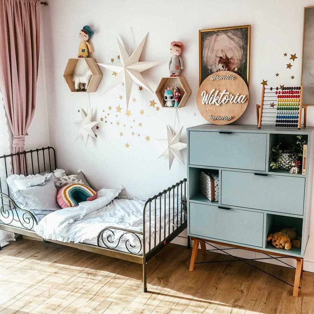 5. Child's bedroom with gold star wall stickers, decorative shelves, and personalized name sign