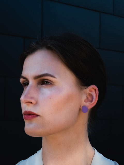 1. Woman wearing Lisa Kroeber Jewellery MINI earrings in Caiman Purple, outdoor setting
