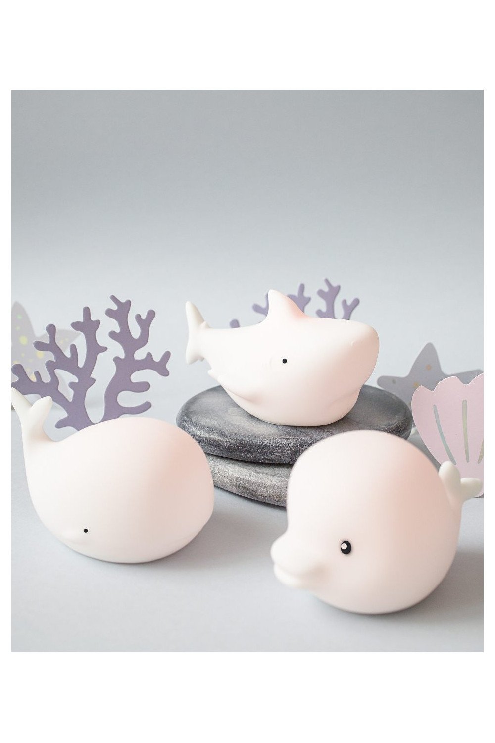 2. Set of three white silicone marine lamps, Dolphin, Whale, and Shark, on a decorative surface with coral accents