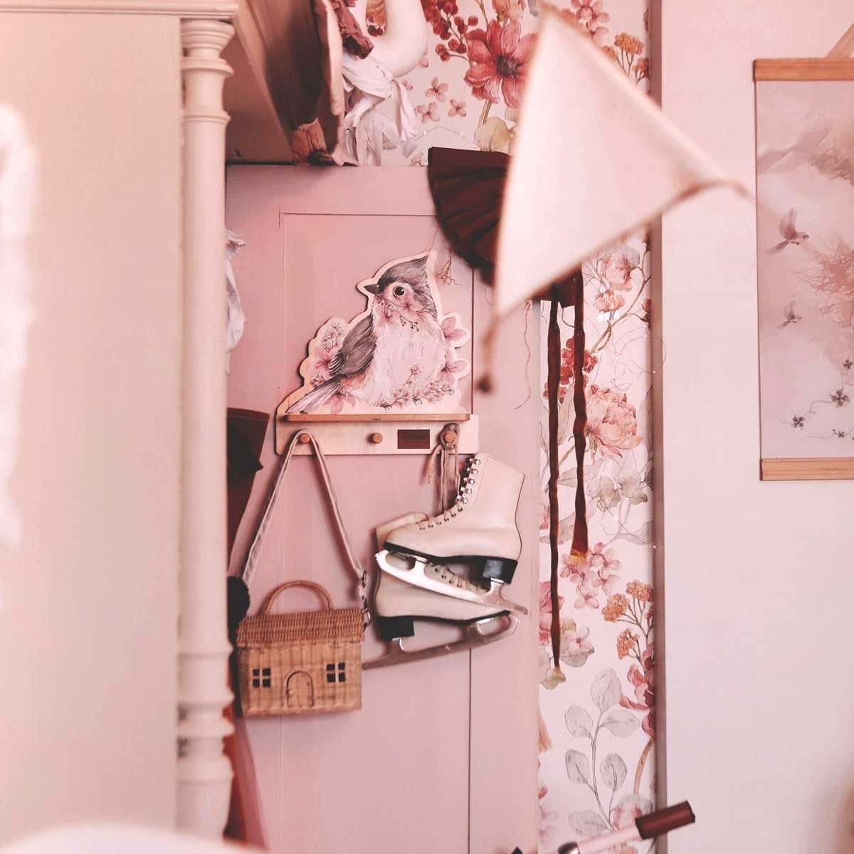 3. Mini wall shelf with bird design on a floral wallpapered door, holding ice skates and a bag