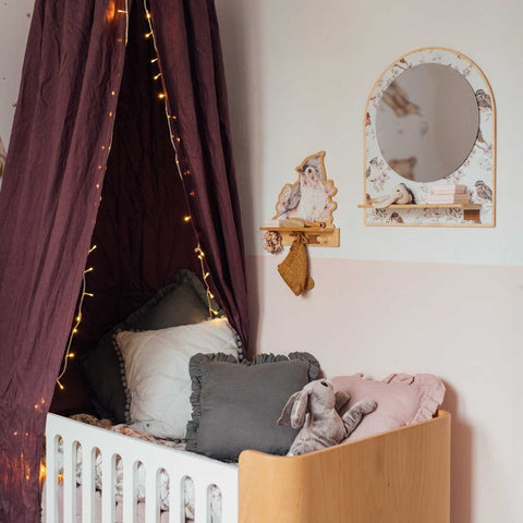5. Mini wall shelf with bird design mounted above a crib in a nursery, decorated with fairy lights