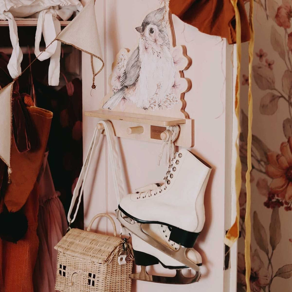 2. Mini wall shelf with bird design in a closet setting, holding ice skates and a wicker bag