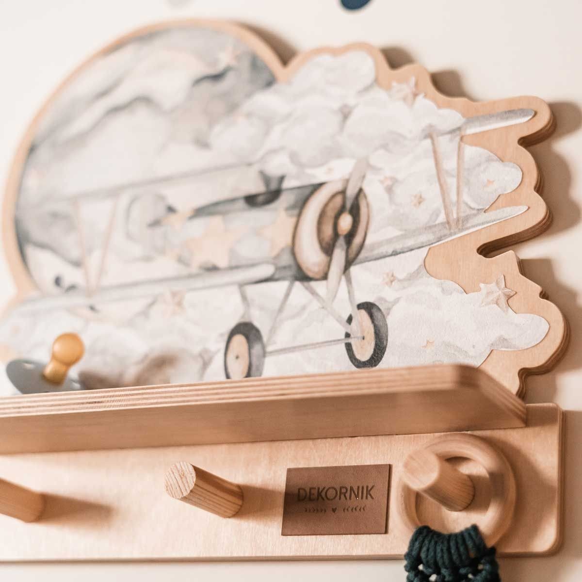 3. Close-up of Dekornik mini wall shelf showing detailed plane design and wooden pegs