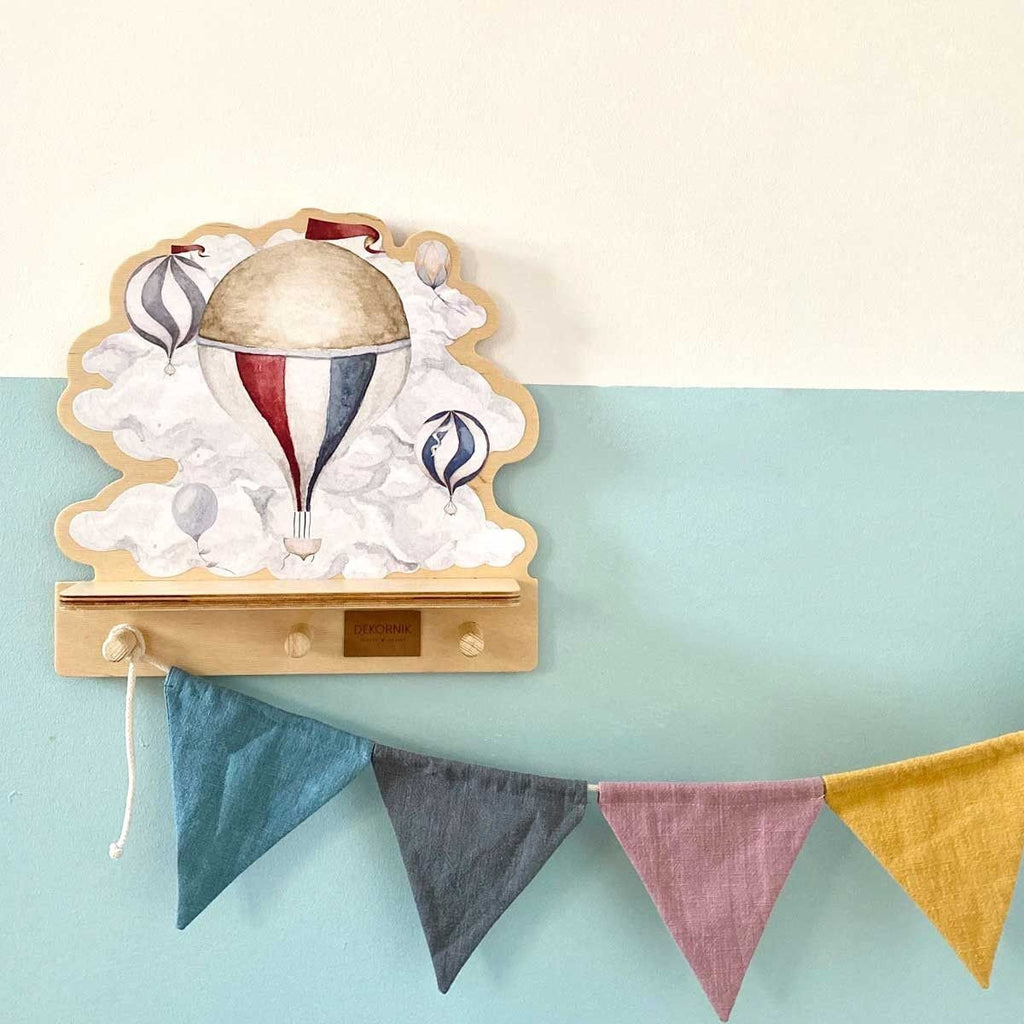 1. Mini wall shelf with hot air balloon design mounted on a pastel wall, featuring colorful bunting below