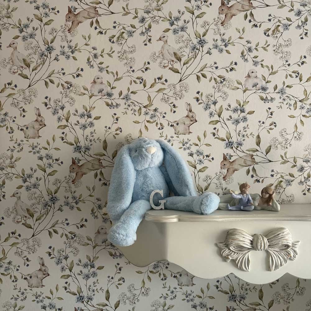 1. Nursery room with beige wallpaper featuring ducks and bunnies, blue plush bunny on white shelf