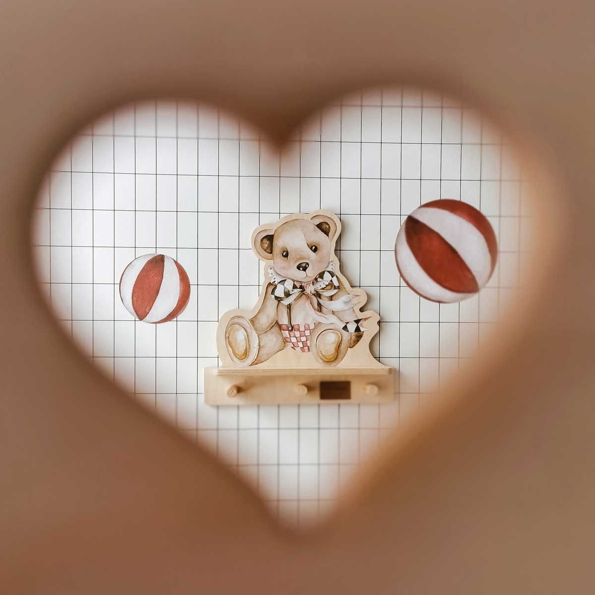 1. Dekornik mini wall shelf with teddy bear design viewed through heart-shaped cutout, set against grid wallpaper