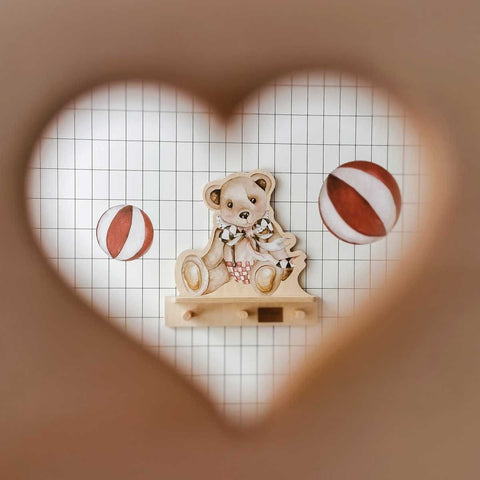 1. Dekornik mini wall shelf with teddy bear design viewed through heart-shaped cutout, set against grid wallpaper