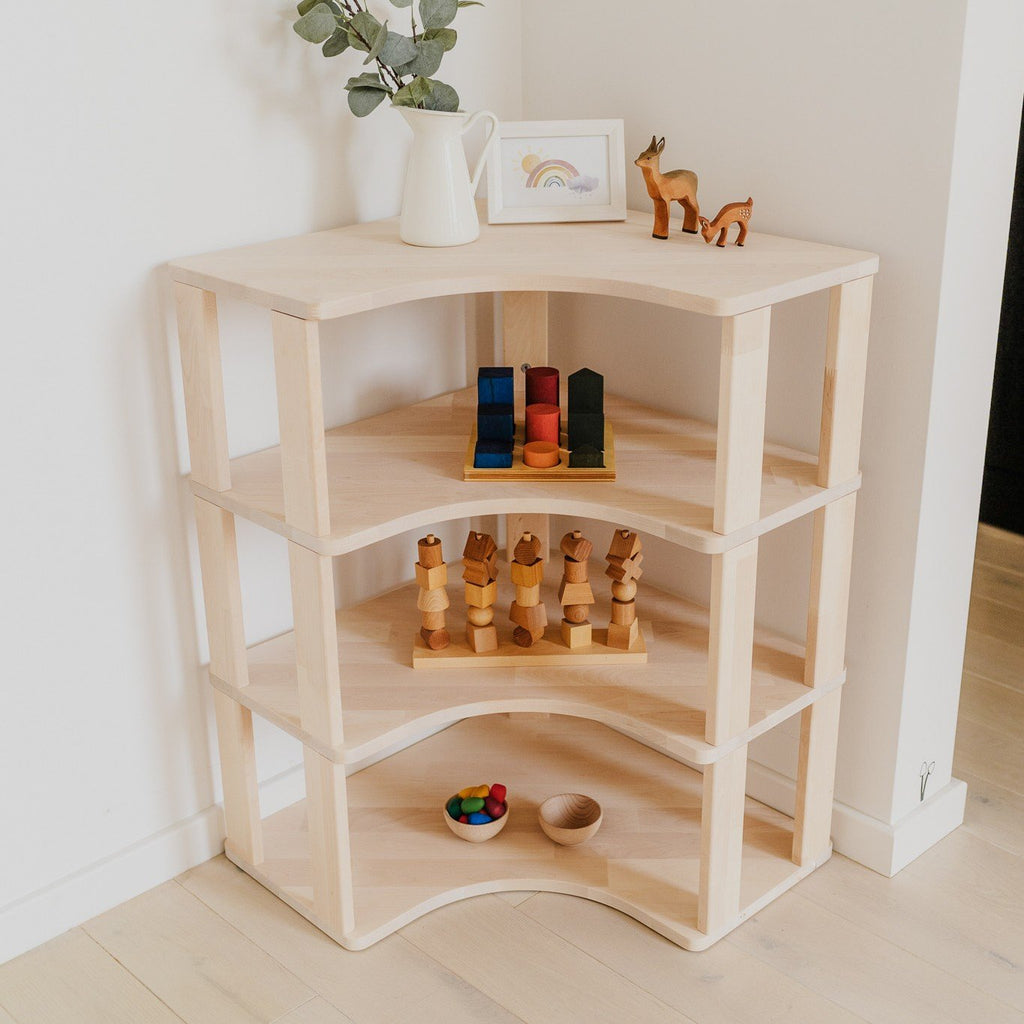 2. Modular Montessori corner shelf with wooden toys and decor in a corner setting