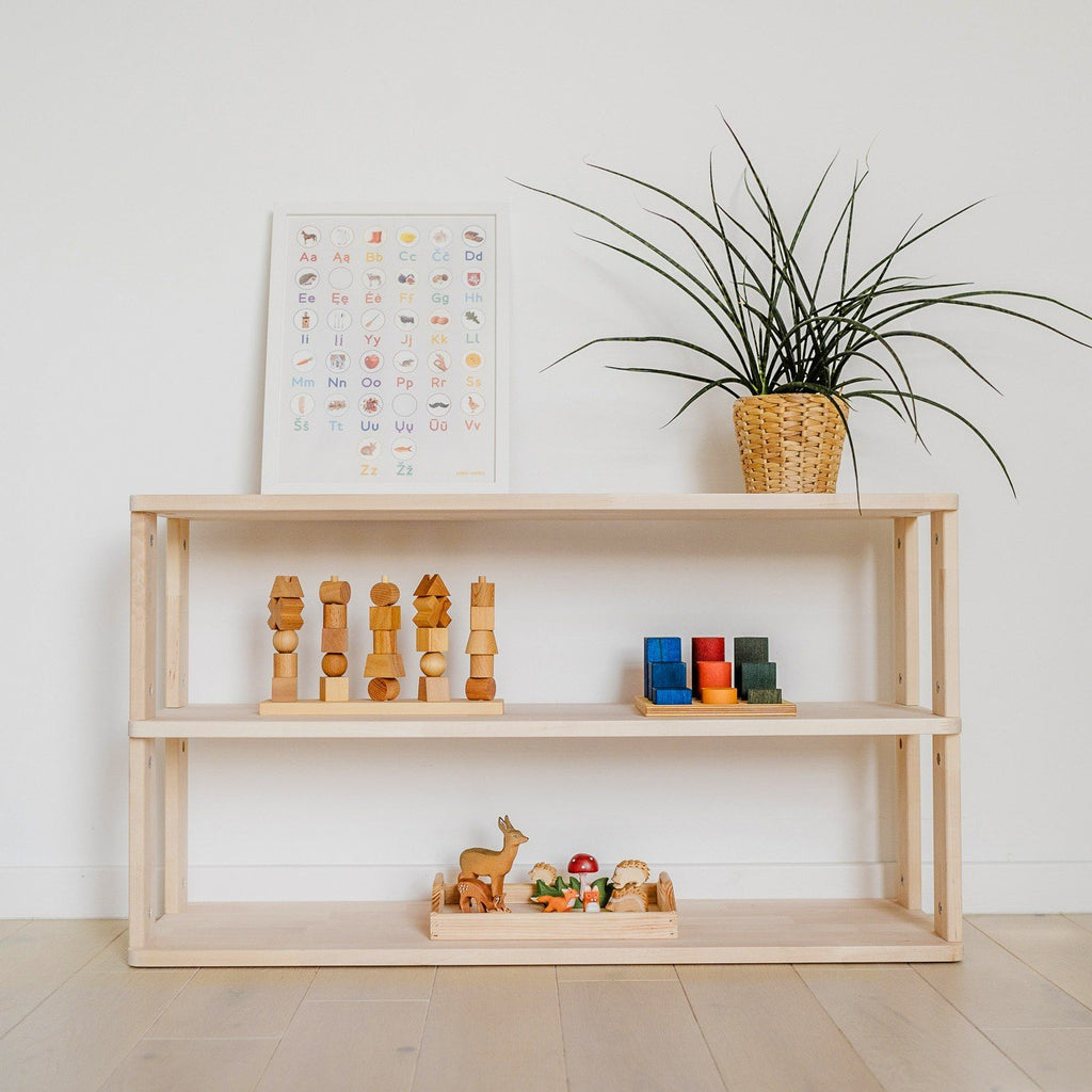 1. Solid wood Montessori shelf with three levels, decorated with wooden toys and a plant, against a white wall