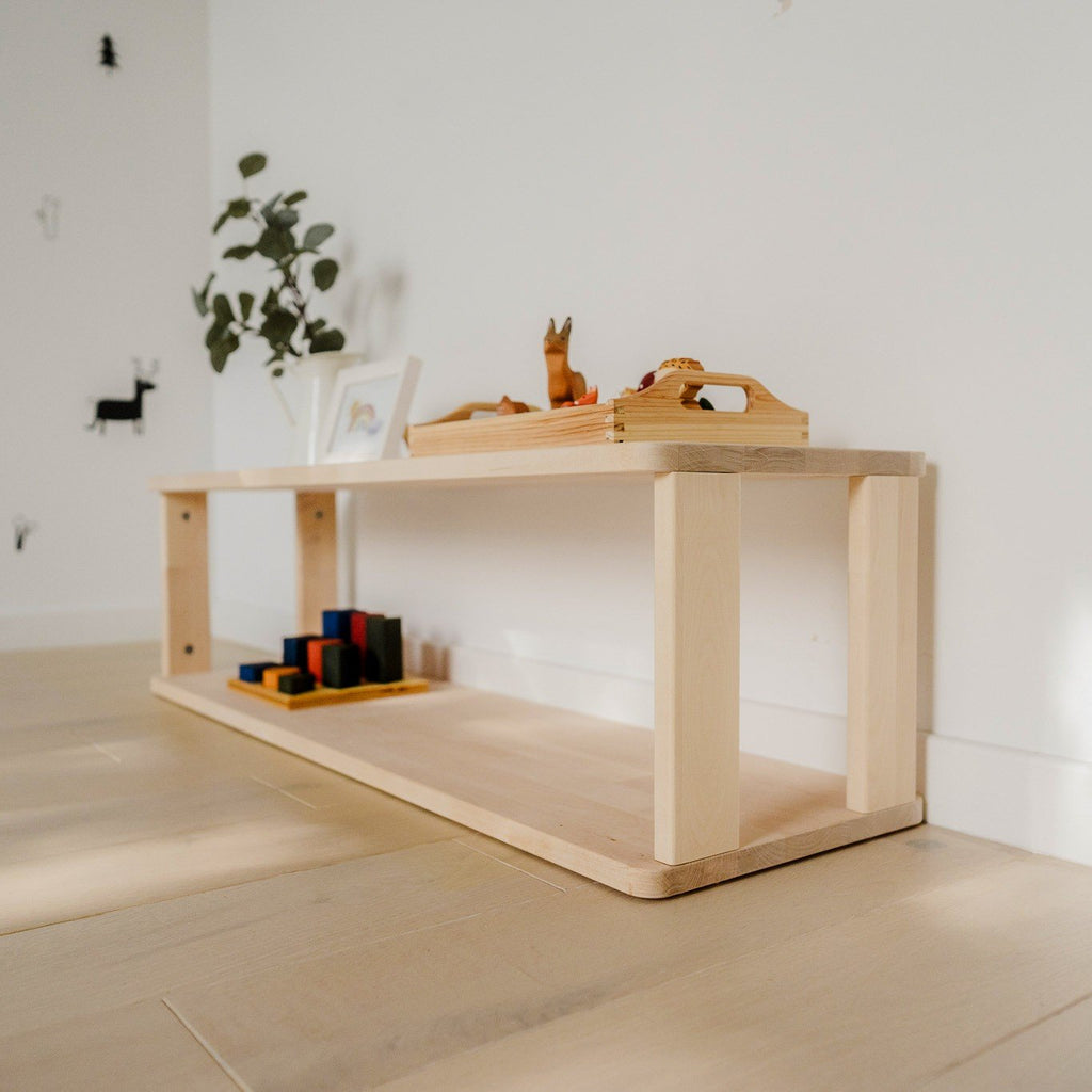3. Side view of natural wood Montessori shelf with toys and decor on light wood floor