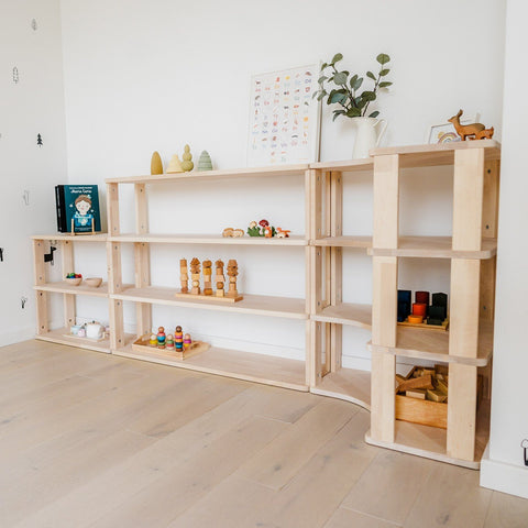 3. Modular Montessori shelving system with toys and books, in a children's playroom with light wood flooring