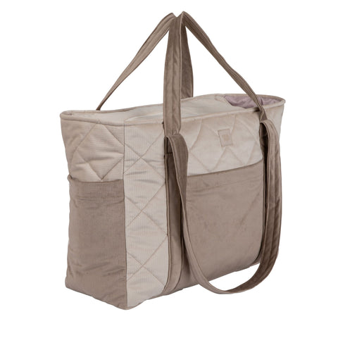 2. Beige mom weekender bag with quilted pattern and long straps shown from side in studio lighting