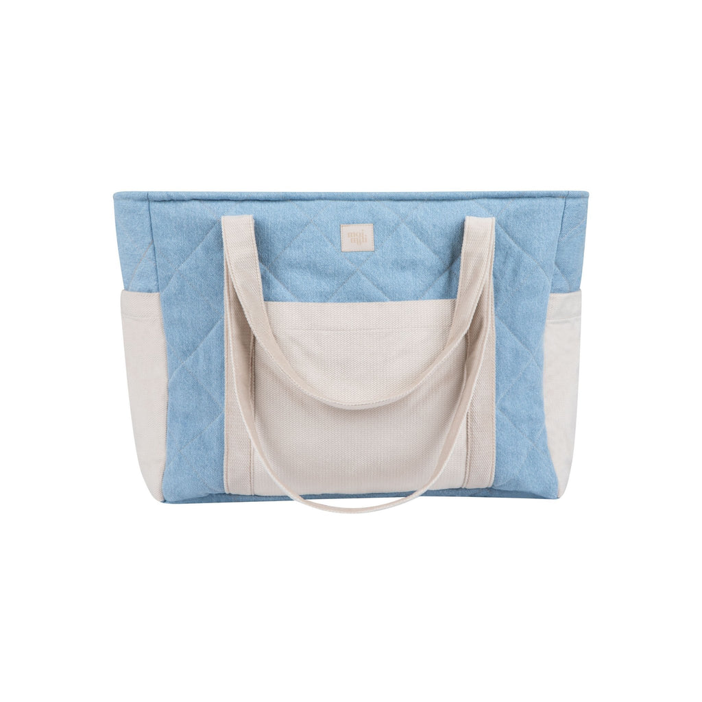 1. Studio shot of blue and beige quilted weekender bag with dual handles and outer pockets by Moi Mili