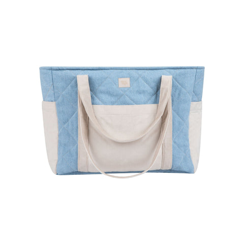 1. Studio shot of blue and beige quilted weekender bag with dual handles and outer pockets by Moi Mili