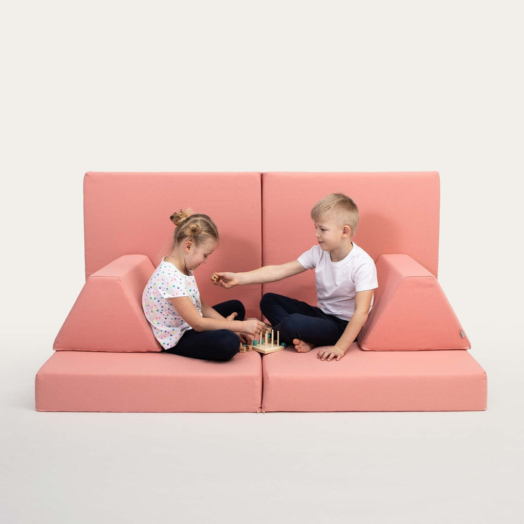1. Two children playing on Monboxy salmon pink activity play mattress set with trapezoidal pillows in a studio setting