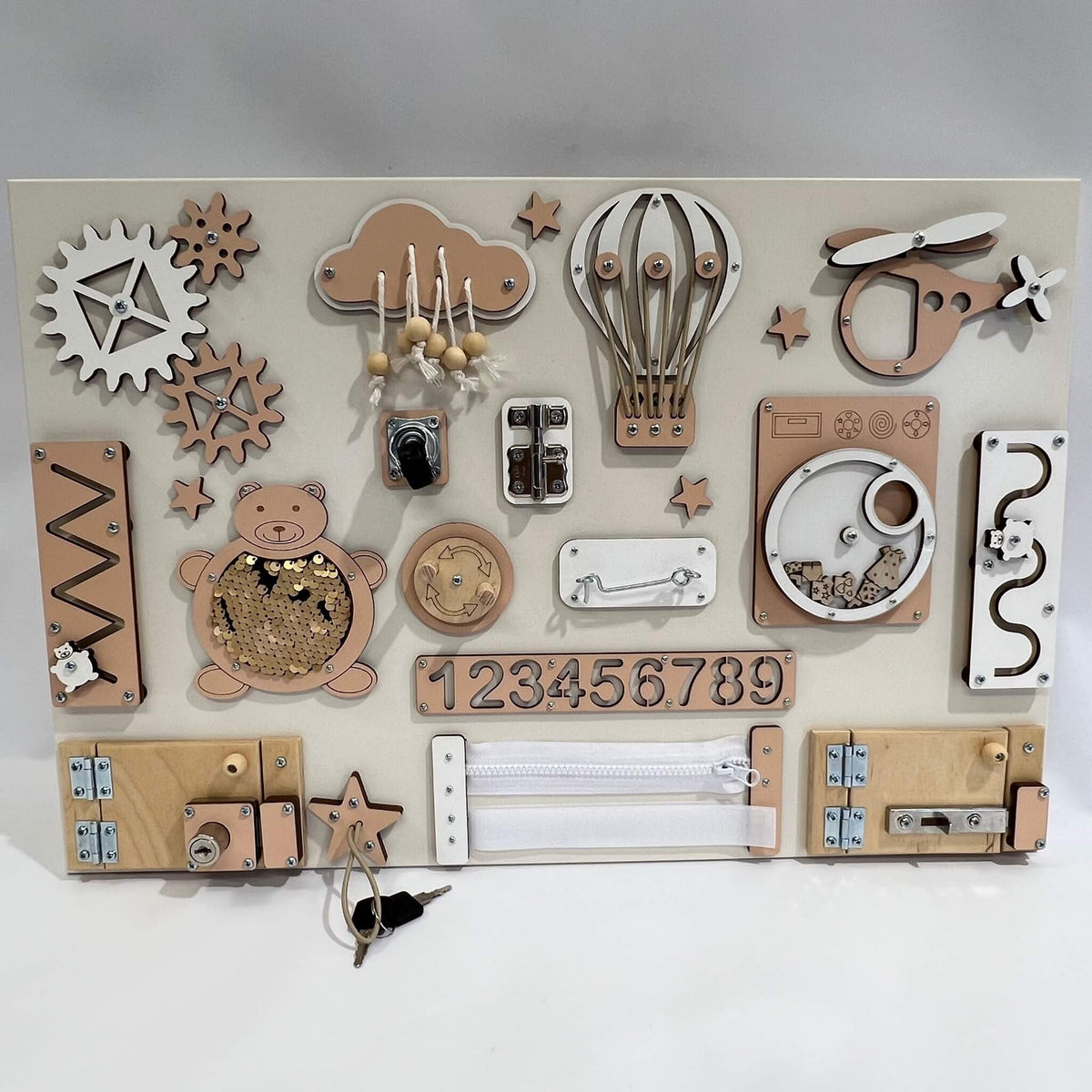 2. Montessori busy board with beige and brown elements featuring locks, gears, and numbers on a white background