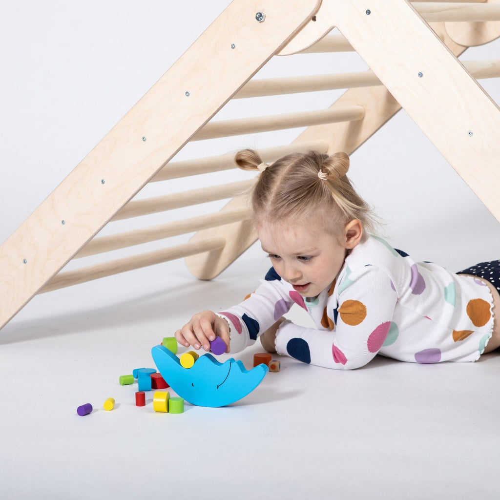 7. Close-up of young girl playing with colorful blocks under Montessori Climbing Triangle