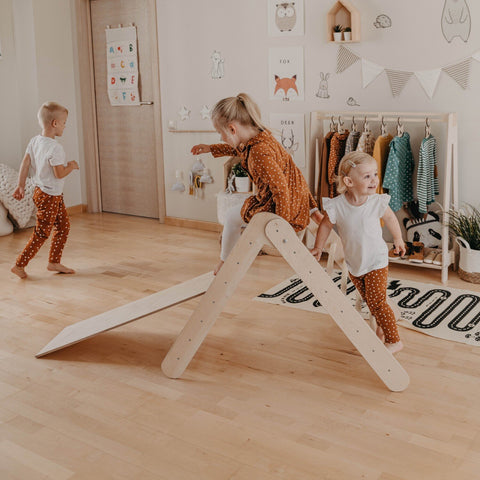 1. Three children enjoying Montessori climbing triangle with ramp in a playroom, showcasing group activity