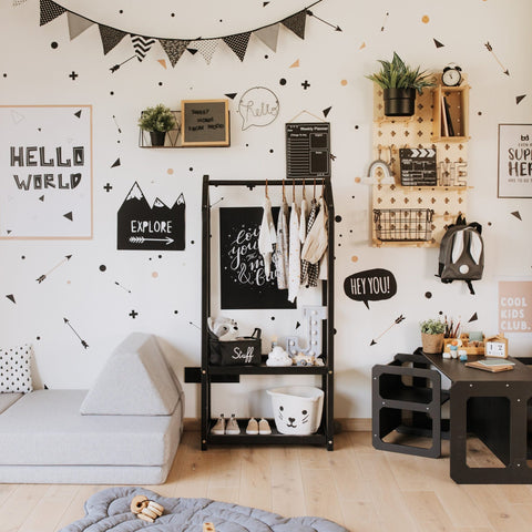 1. Black house-shaped clothing rack with children's clothes in a modern kids' room