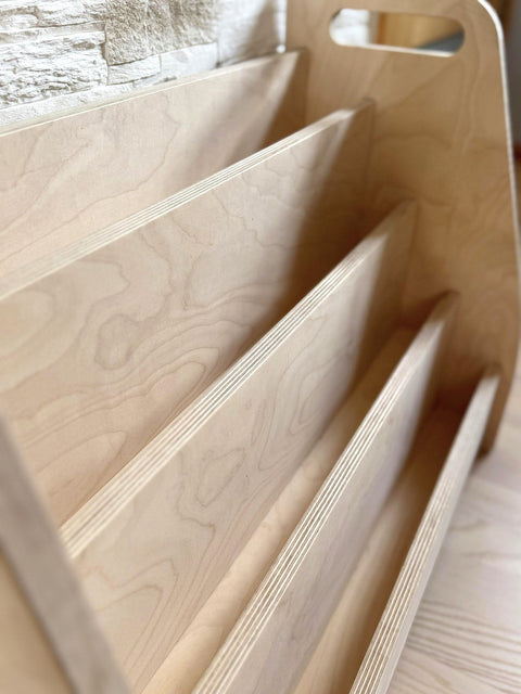 3. Close-up of the birch plywood texture and construction details of the Montessori book display's front-facing tiers.