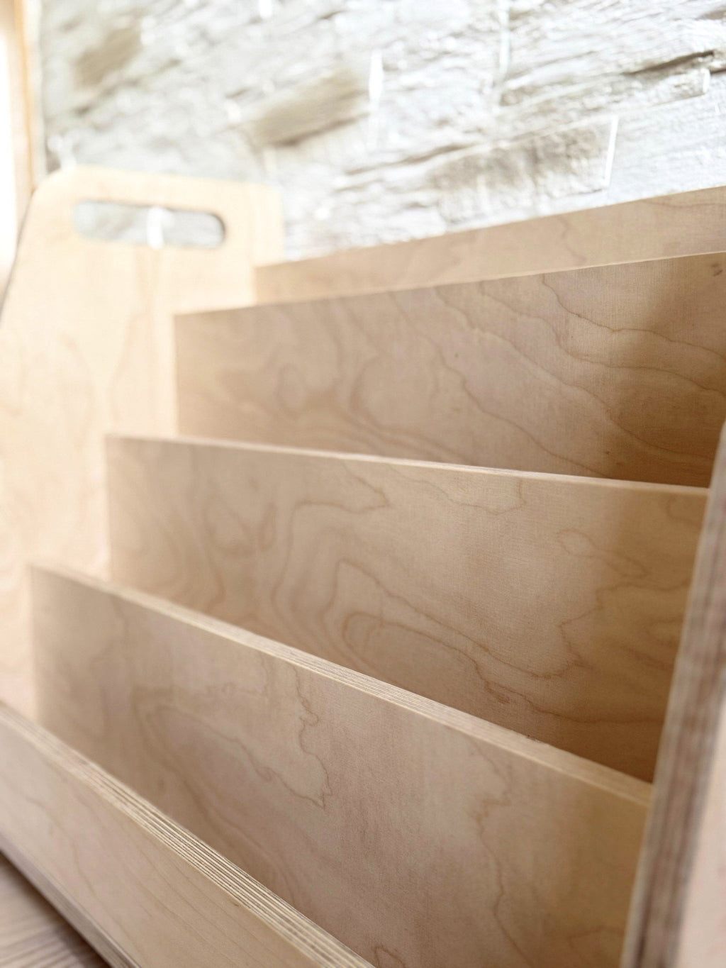 4. Detailed view of the Montessori book display's tiered design, emphasizing the natural wood grain and craftsmanship.