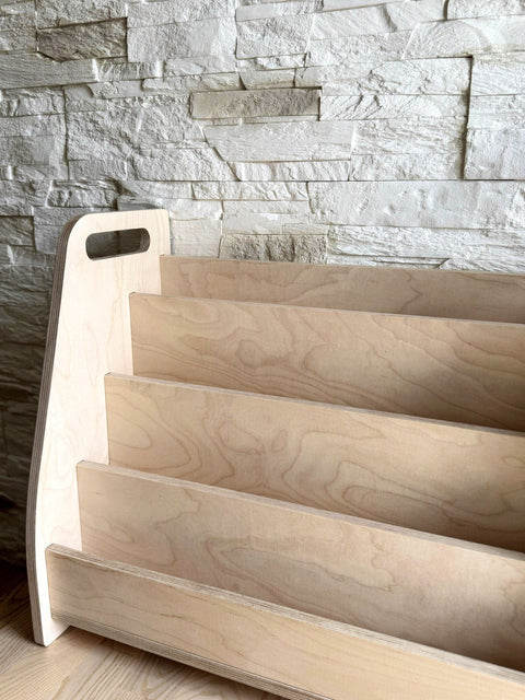 2. Studio shot of Montessori-inspired book display shelf made from birch plywood, highlighting the front-facing tiers and rounded side handles.