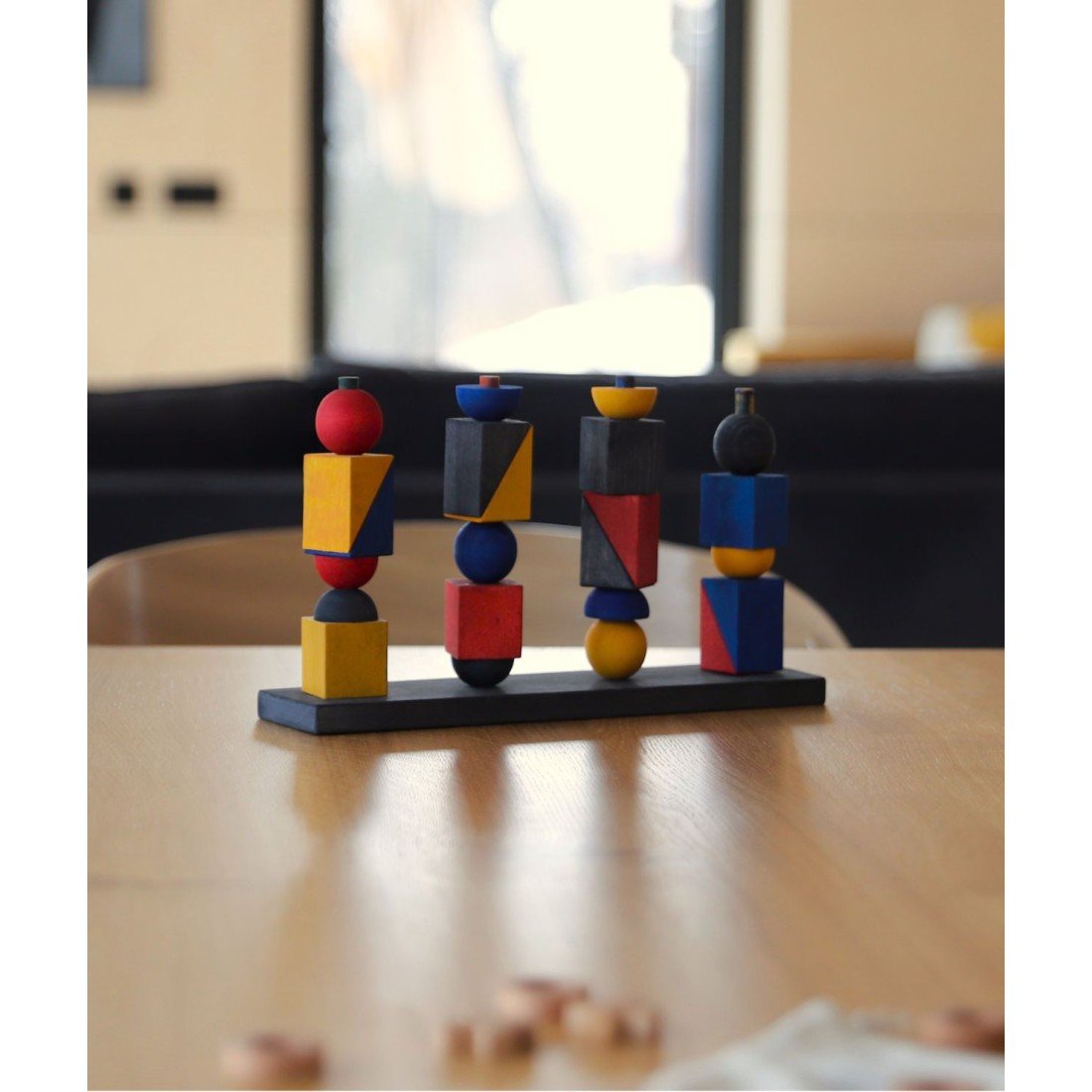 1. Montessori-inspired stacking toy with geometric shapes on a wooden table in a modern living room